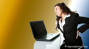a person Ashburn bending over a computer holding her back due to pain